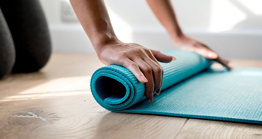 Core exercises for seniors: Woman rolling a yoga mat