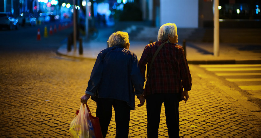 ADLS: Two elderly female friends crossing the street