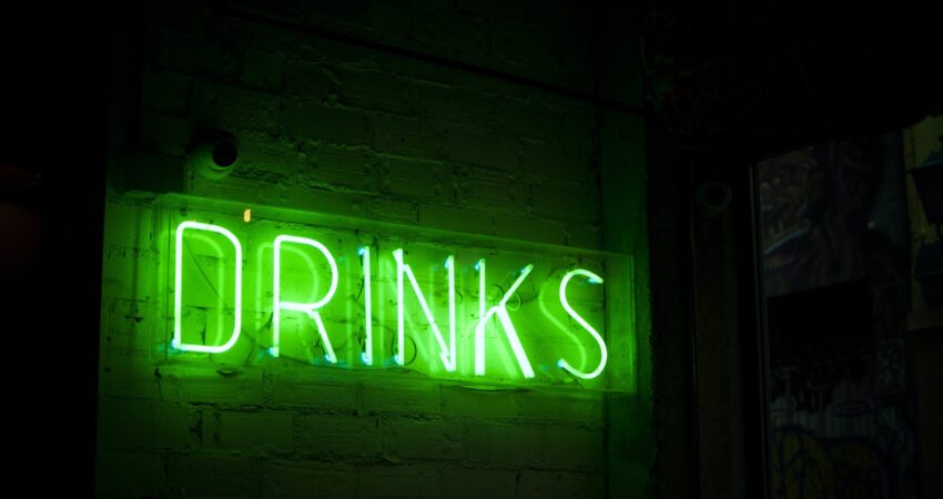 green drinks neon sign for article on alcohol consumption during COVID-19 pandemic