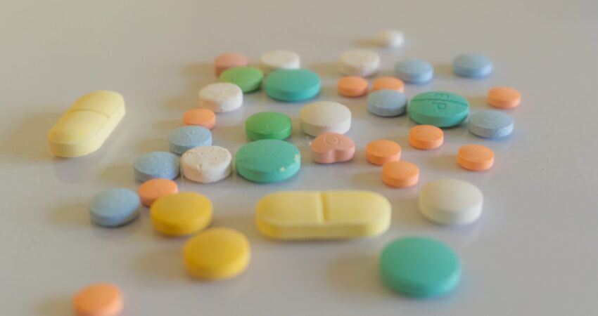 white yellow and teal medication pill