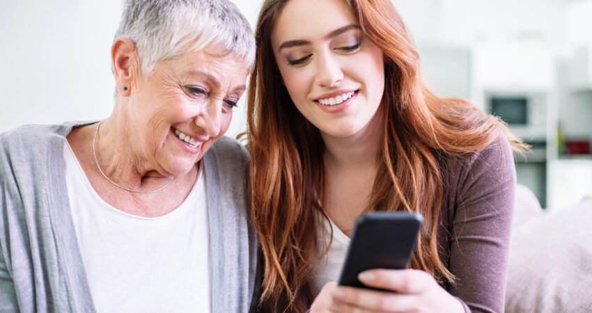 picture of daughter looking at phone app with mother